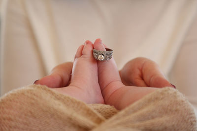 Cropped image of mother with baby wearing ring in toenail