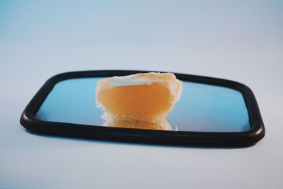 Close-up of ice cream in plate against white background
