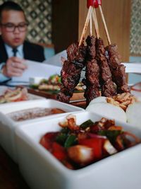 Close-up of food with businessman in background