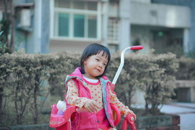 Portrait of cute girl with arms raised