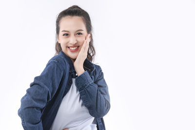 Portrait of a smiling young woman against white background