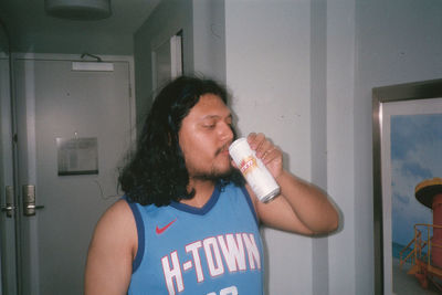 Portrait of mature man drinking glass at home