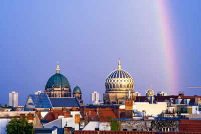 View of buildings in city against clear blue sky
