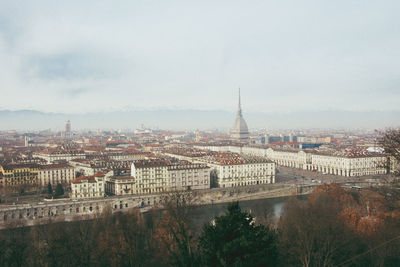 Aerial view of buildings in city against sky