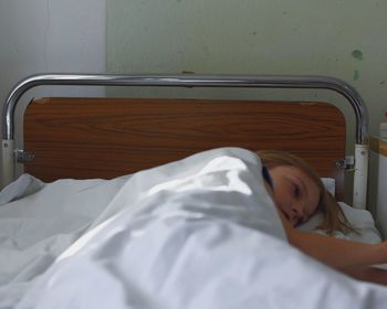 Portrait of kid lying in hospital bed