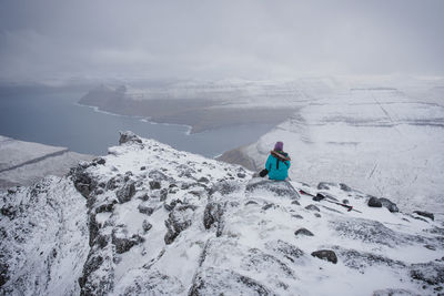 Person on snowcapped mountain against sky