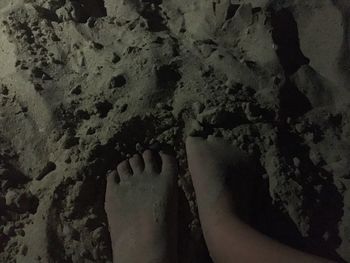 Low section of person standing on sand