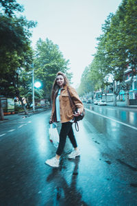 Full length of man standing on road in city