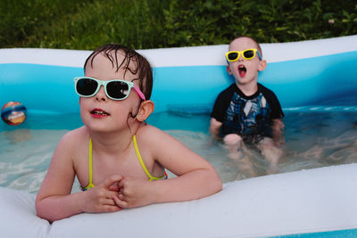 Wet serious children in the pool in sunglasses. summer is a time of pleasure and fun