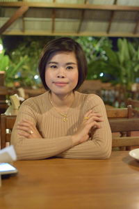 Portrait of a smiling young woman sitting at restaurant