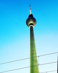 Low angle view of communications tower against blue sky