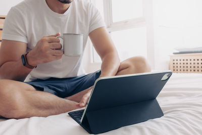 Midsection of man using mobile phone