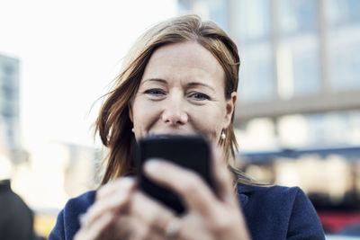 Businesswoman using mobile phone outdoors