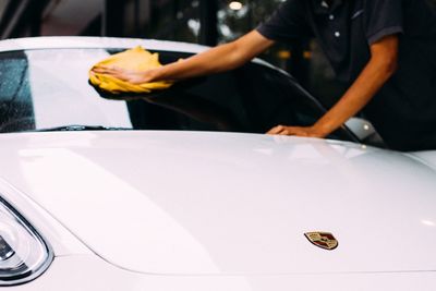 Midsection of man standing by car