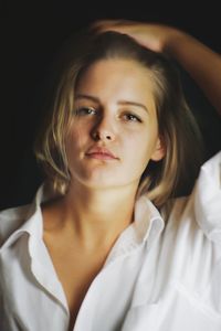 Portrait of beautiful young woman lying on bed