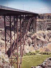 Arch bridge over river against sky