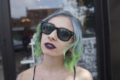 A young woman wearing black sunglasses.