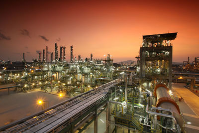 Illuminated factory against sky at night