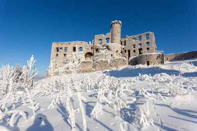 Historic building against clear blue sky during winter