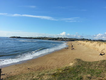 Scenic view of beach against cloudy sky