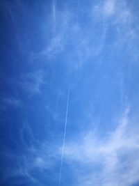 Low angle view of vapor trail against blue sky