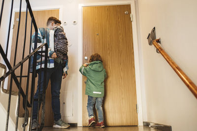 Mother with children entering apartment