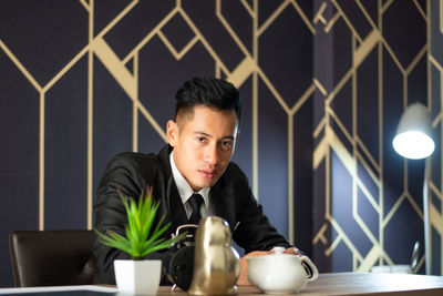 Portrait of young man sitting at table