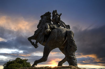 Low angle view of the statue against sky during sunset