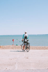 Bicycle on beach by sea against sky