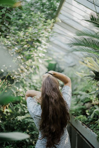 Rear view of woman standing by plants