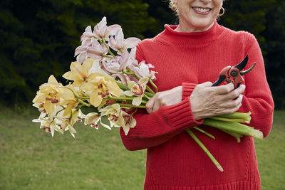 Smiling grandma holding fresh cut flowers from the garden