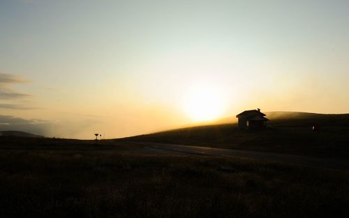 Scenic view of silhouette field against sky during sunset