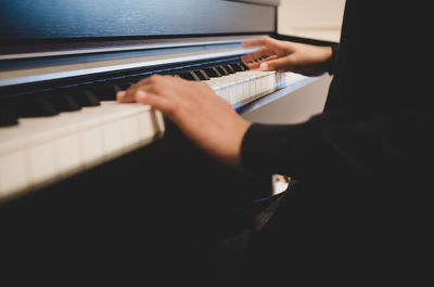 Midsection of man playing piano