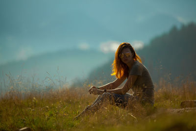 Girl sitting on the grass in the carpathian mountains