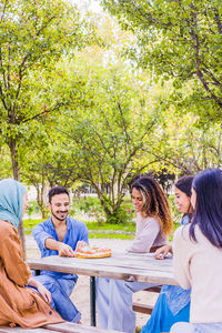 Cheerful friends having food outdoors