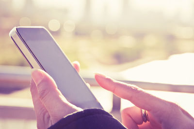 Cropped image of woman using mobile phone