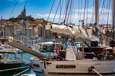 Sailboats moored at harbor against sky