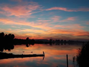 Scenic view of lake against orange sky