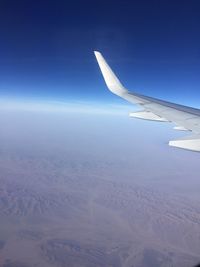 Cropped image of airplane flying over landscape