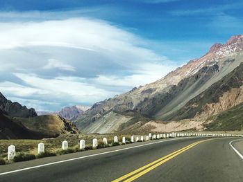 Road leading towards mountains against sky