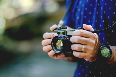 Midsection of man holding camera