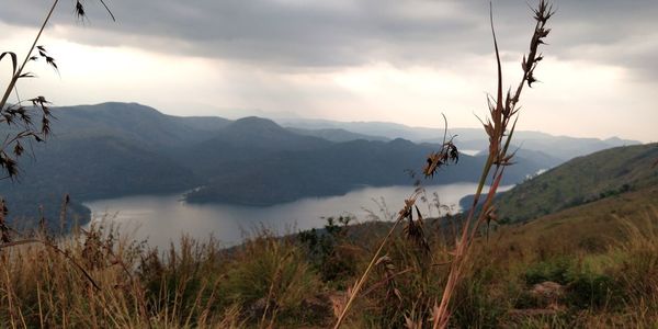 Scenic view of land and mountains against sky
