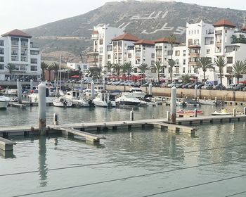 Boats moored in harbor at town