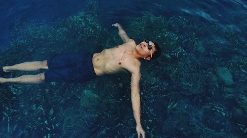 High angle view of man floating on sea