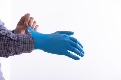 Close-up of hand holding paper over white background