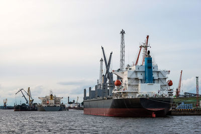 Ship moored at harbor against sky