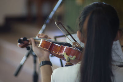 Rear view of woman playing violin