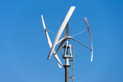 Low angle view of windmill against clear blue sky