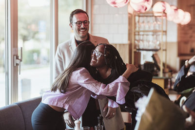 Female friends greeting in restaurant during party afterwork