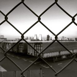 Cityscape seen through chainlink fence